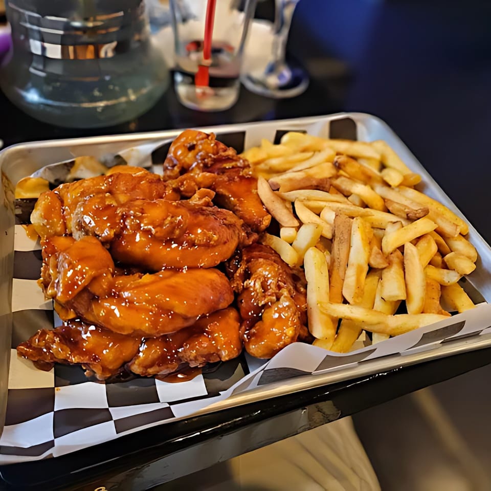 Cali Kitchen and Bar's chicken wings with sweet glaze and a side of golden french fries.